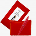 Portamonete rosso intenso con piccola penna abbinata presentato in un sacchetto di carta regalo con adesivo per matrimoni