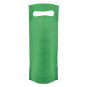 Vino personalizzato con adesivo rotondo per la comunione del bambino presentato in un sacchetto verde