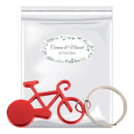 Portachiavi a forma di bicicletta presentato in una busta con patella adesiva e adesivo erbaceo personalizzabile